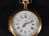a gold pocket watch with roman numerals on the face