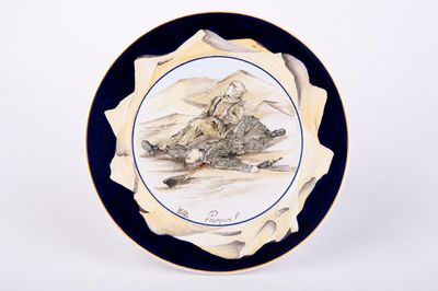 a blue and white plate with a picture of a mountain scene on it