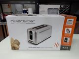 packaging of a silver toaster sitting on top of a white table