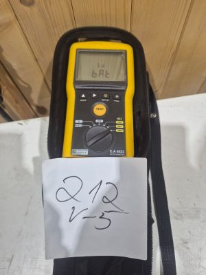 un multimètre numérique jaune et noir sur lequel est collée une note