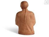 a clay figurine of a woman with long hair