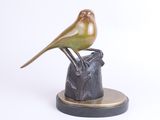statue of a bird perched on a rock on a white background