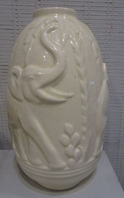 un vase blanc orné d'un oiseau, posé sur une table