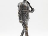 statue of a man in uniform holding a baseball bat on a rock