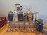 a lot of beer glasses and a pitcher on a table