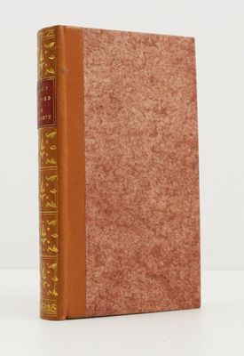 un vieux livre à la couverture marron posé sur une table blanche