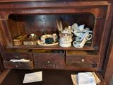 une petite armoire en bois sur laquelle sont posés de nombreux objets