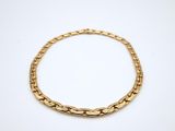 a gold chain bracelet on a white background