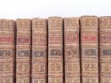 several old books are stacked on top of each other on a table