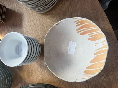 de nombreuses assiettes et tasses posées sur une table, accompagnées d'une étiquette