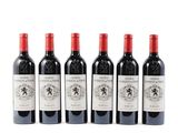 quatre bouteilles de vin rouge sont alignées sur une surface blanche