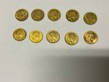 a bunch of gold coins sitting on top of a white table