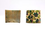 two pieces of metal with flowers on them sitting next to each other