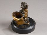 bronze figurine of a boy playing a trumpet on a black base
