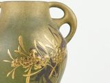a green vase with a gold design on it