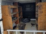 the back of a van with the door open and shelves in the back of it