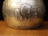 a silver bowl sitting on top of a wooden table