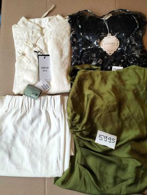 trois vêtements posés sur une boîte en carton