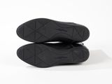 the soles of a pair of black shoes on a white surface