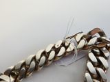 un bracelet en argent posé sur une table blanche