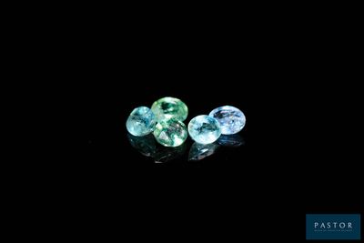 a couple of blue and green gems sitting on top of a black surface