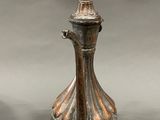 an image of a silver vase with a bird on top