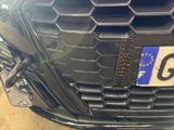 a close up of a car ' s grille with a number plate on it