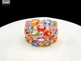 a ring with multi colored stones on a white plate