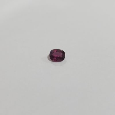 a purple oval shaped gems on a white surface