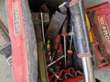 une sacoche à outils posée par terre, contenant des outils
