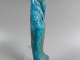 an image of a blue sculpture of a woman on a clear stand