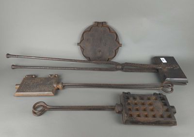 une photo montrant une collection d'outils anciens en fer posés sur une table