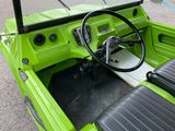 a green car with a steering wheel and a dashboard