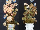 two vases that have flowers in them on a black table