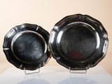 two silver plates that are sitting on a table