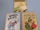 three children ' s books are lined up on a blue surface