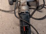 a drill that is laying on the ground next to a piece of metal