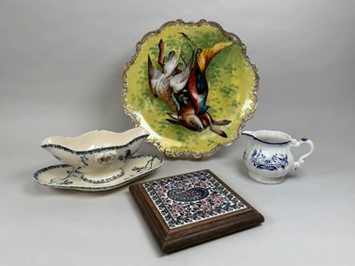 une assiette avec un oiseau dessus, à côté d'un bol et d'une assiette avec un oiseau dessus