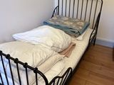 un lit sur lequel se trouve un oreiller, dans une chambre