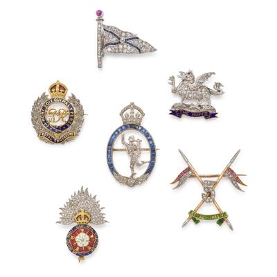 six different types of brooches and badges on a white surface