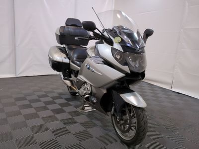une moto qui est garée dans une pièce dont le sol est en damier