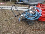 a small cart with a hose attached to it on the ground