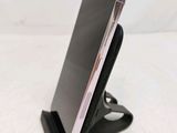the phone is sitting on the stand on the bed