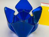 a blue glass bowl sitting next to a yellow box