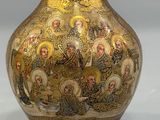 a gold vase with a picture of jesus and other people on it