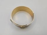a close up of a gold bracelet on a white surface