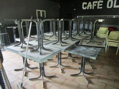 many tables and chairs in a room with a cafe sign on the wall