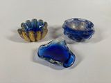 three blue glass bowls sitting on top of a table next to each other