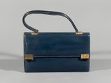 the small blue purse is sitting on a white surface
