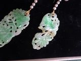 pair of jade and pearl earrings in a box with pearls